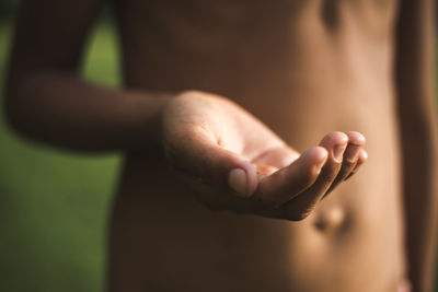 Midsection of shirtless man showing hands