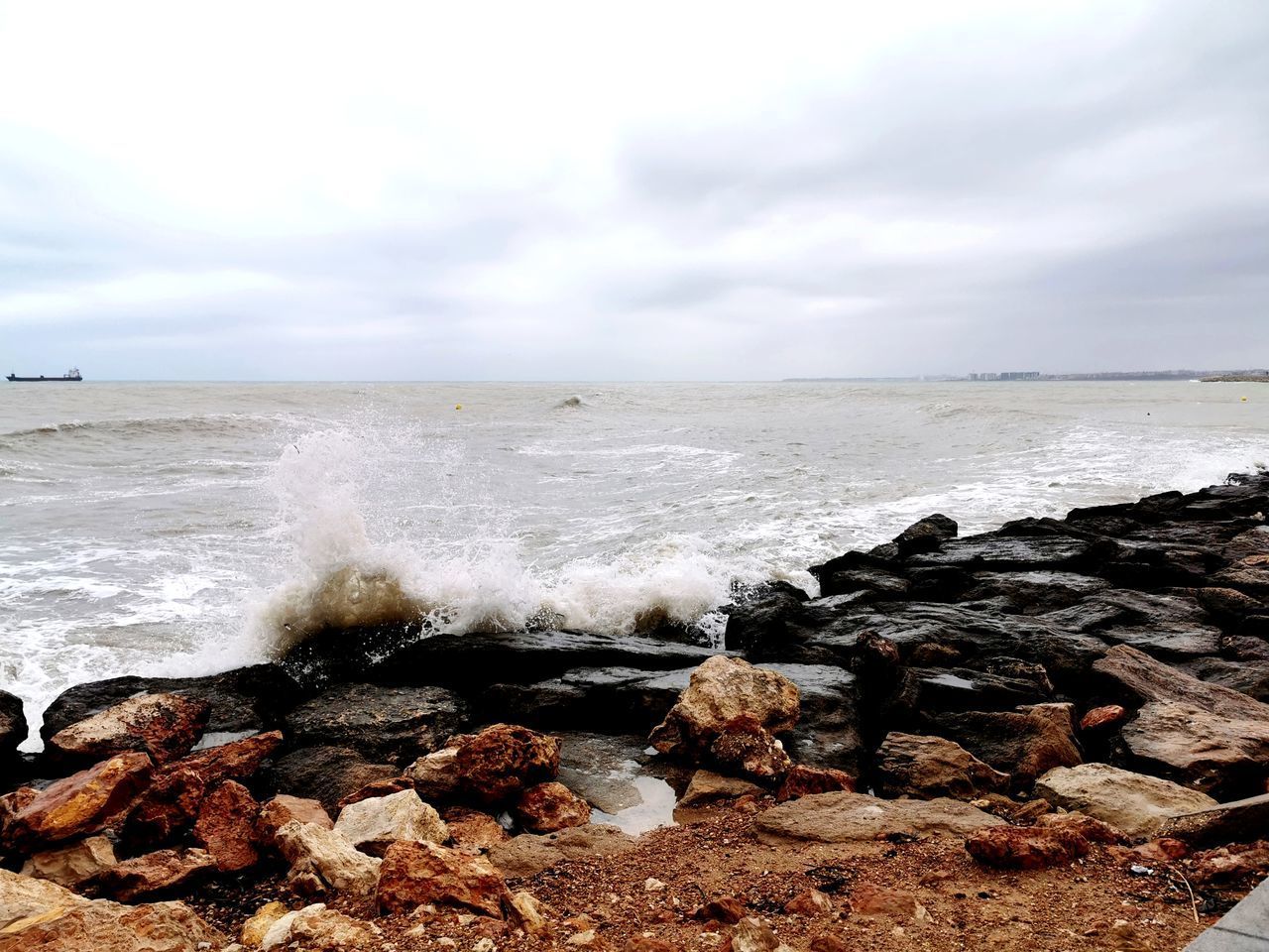 SCENIC VIEW OF ROCKS ON BEACH AGAINST SKY