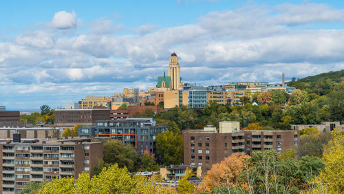 Buildings in city against cloudy sky