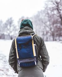 Rear view of man on snow covered landscape against sky