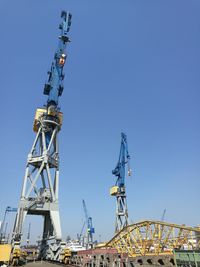 Low angle view of ferris wheel against clear blue sky