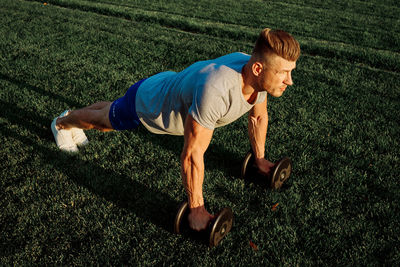 Side view of man exercising on field