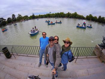 High angle portrait of tourists standing on steps by lake