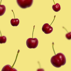 Pattern with ripe flying cherry on yellow background, wallpaper