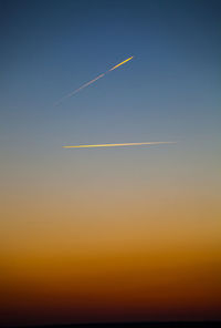 Scenic view of vapor trails in sky during sunset