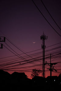 Low angle view of silhouette electricity pylon against sky at sunset