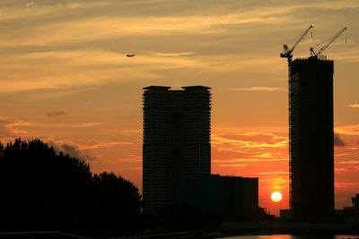 Low angle view of silhouette buildings against sky at sunset