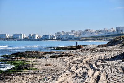 Scenic view of sea and buildings against clear sky