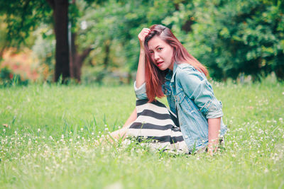 Young woman on grass in field