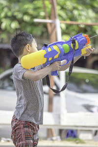 Boy playing with squirt gun outdoors