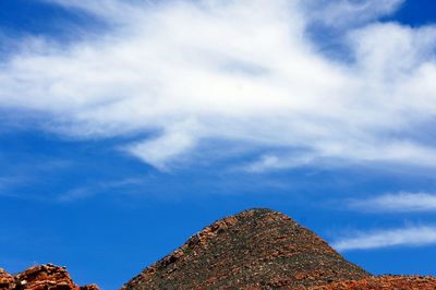 Low angle view of rocks against blue sky