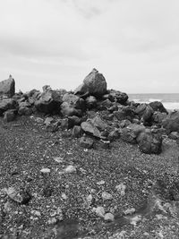 Rock formations on shore against sky