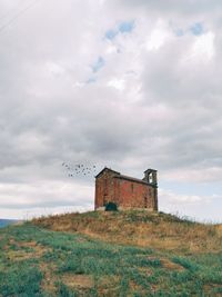 Abandoned building on field against sky