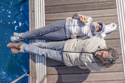 High angle view of couple wearing warm clothing on pier over lake