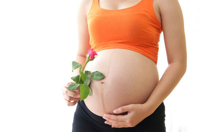 Midsection of woman standing against white background