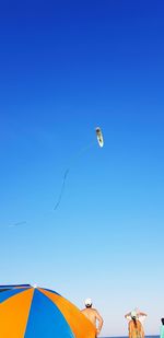 Low angle view of kite flying against clear blue sky