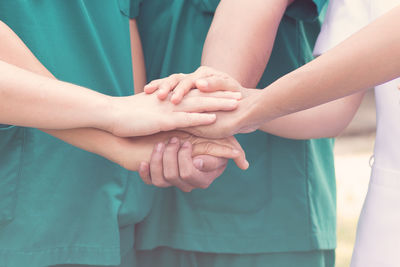 Midsection of doctors and nurses stacking hands