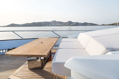 Chairs and table by sea against sky