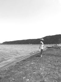 Man standing on beach against clear sky