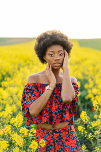 Portrait of beautiful woman standing on field