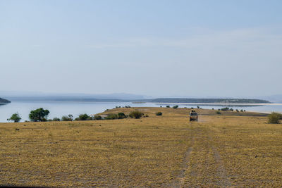 Safari van driving against scenic lake at lake magadi 