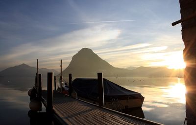 Boat moored on river during sunset