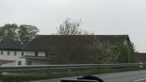 Road by building against clear sky