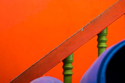 Close-up of railing against orange wall