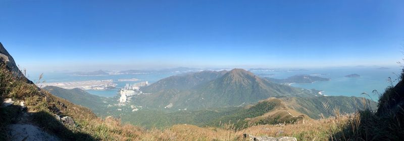 Panoramic view of landscape and mountains against clear blue sky