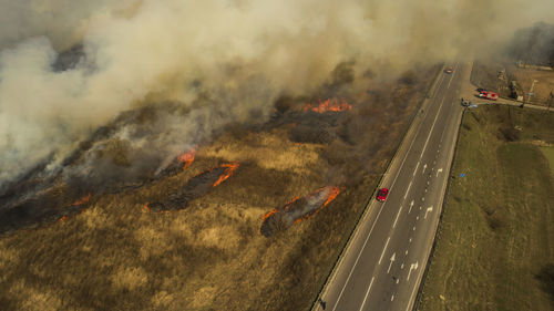 Massive fire, dry grass lanes in fire, firefighters at work, disaster, ecological catastrophe