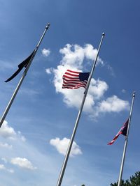 Low angle view of american flags against blue sky