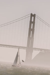 Low angle view of suspension bridge against sky