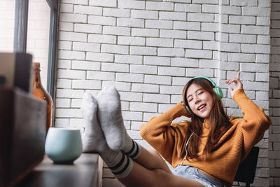 Woman listening music while relaxing at home