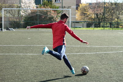 Full length of man playing soccer on field