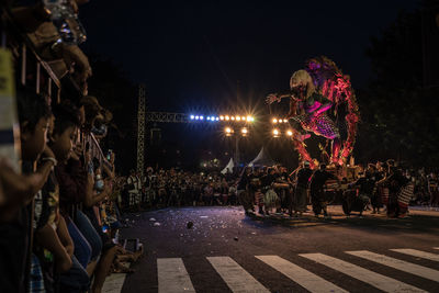 People on illuminated street at night