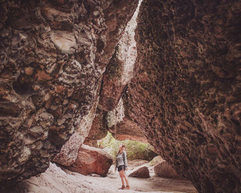 Rear view of man sitting on rock