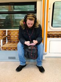 Full length of woman sitting in train