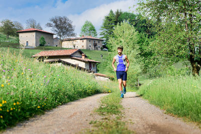 Rear view of man running on footpath