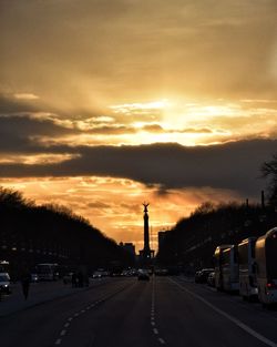 Cars on road against sky during sunset