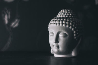 Close-up of statue on table against black background