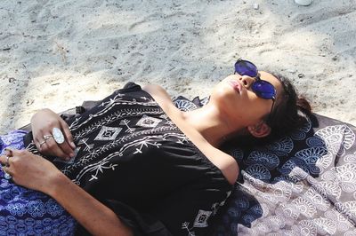 High angle view of woman lying on sand