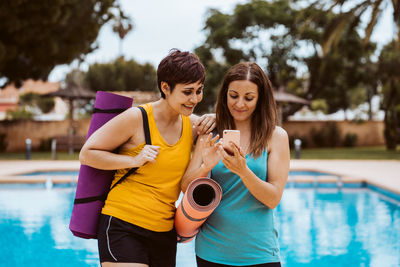 Portrait of smiling young woman standing in swimming pool