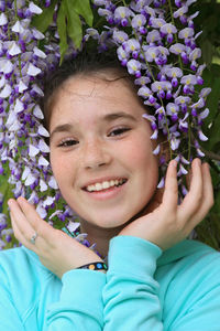 Portrait of teenage girl amidst purple flowers blooming outdoors