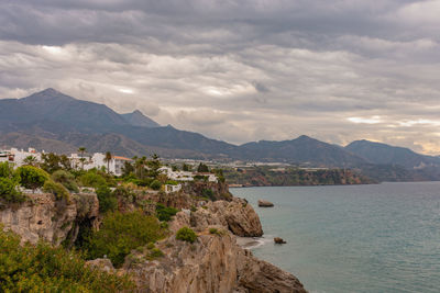 Scenic view of sea and mountains against sky