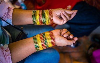 Midsection of woman wearing colorful bangles