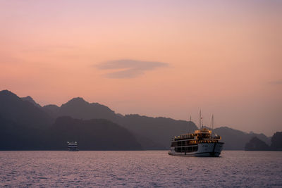 Sailboat sailing on sea against sky during sunset