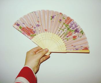 Close-up of person holding umbrella against white background