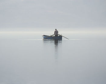 Man sailing on sea against sky