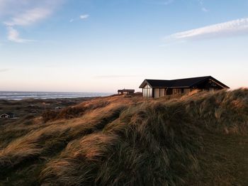 House on beach by sea against sky