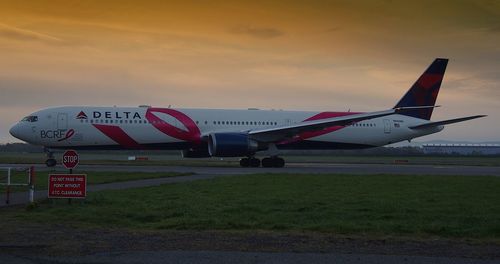 Airplane against sky at sunset